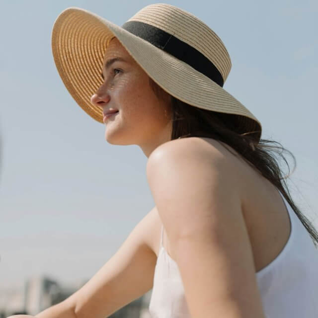 a person with a sun hat on smiling at klara clermont fl apartments